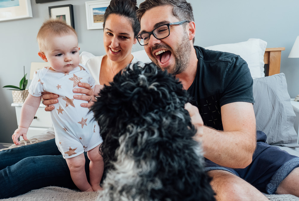 Surrey Family Photographer parents baby and dog on bed