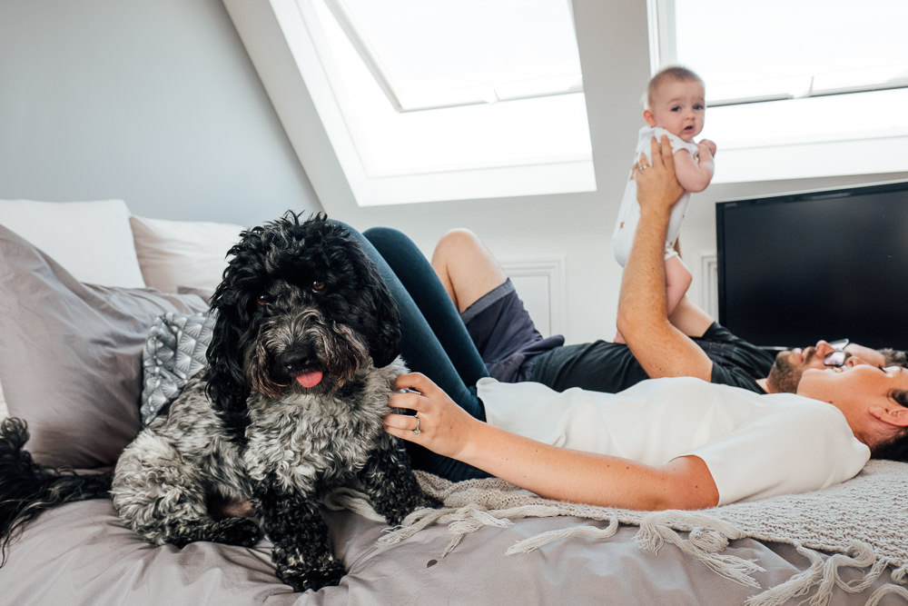 Godstone Surrey Family Photographer parents and dog playing with baby daughter on bed
