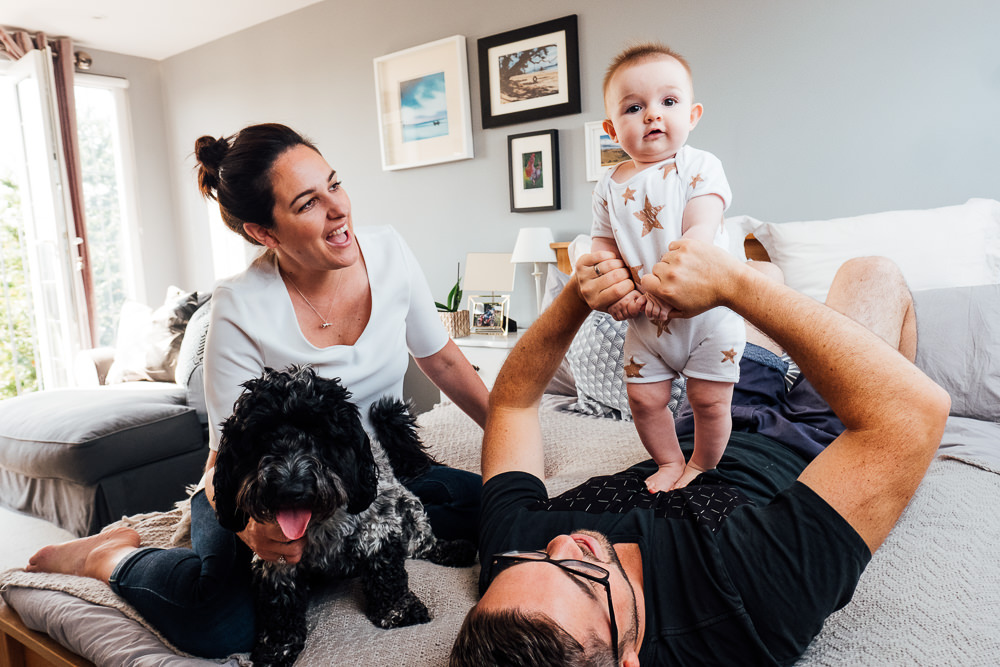 Godstone Surrey Family Photographer parents and dog playing with baby daughter on bed