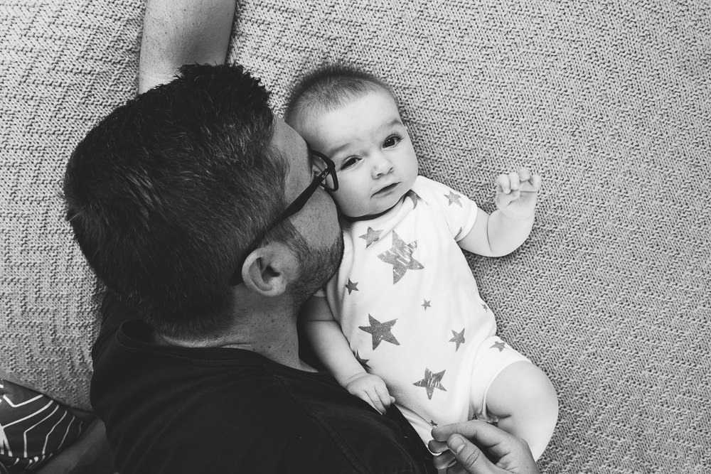 Godstone Surrey Family Photographer father and baby girl on bed smiling