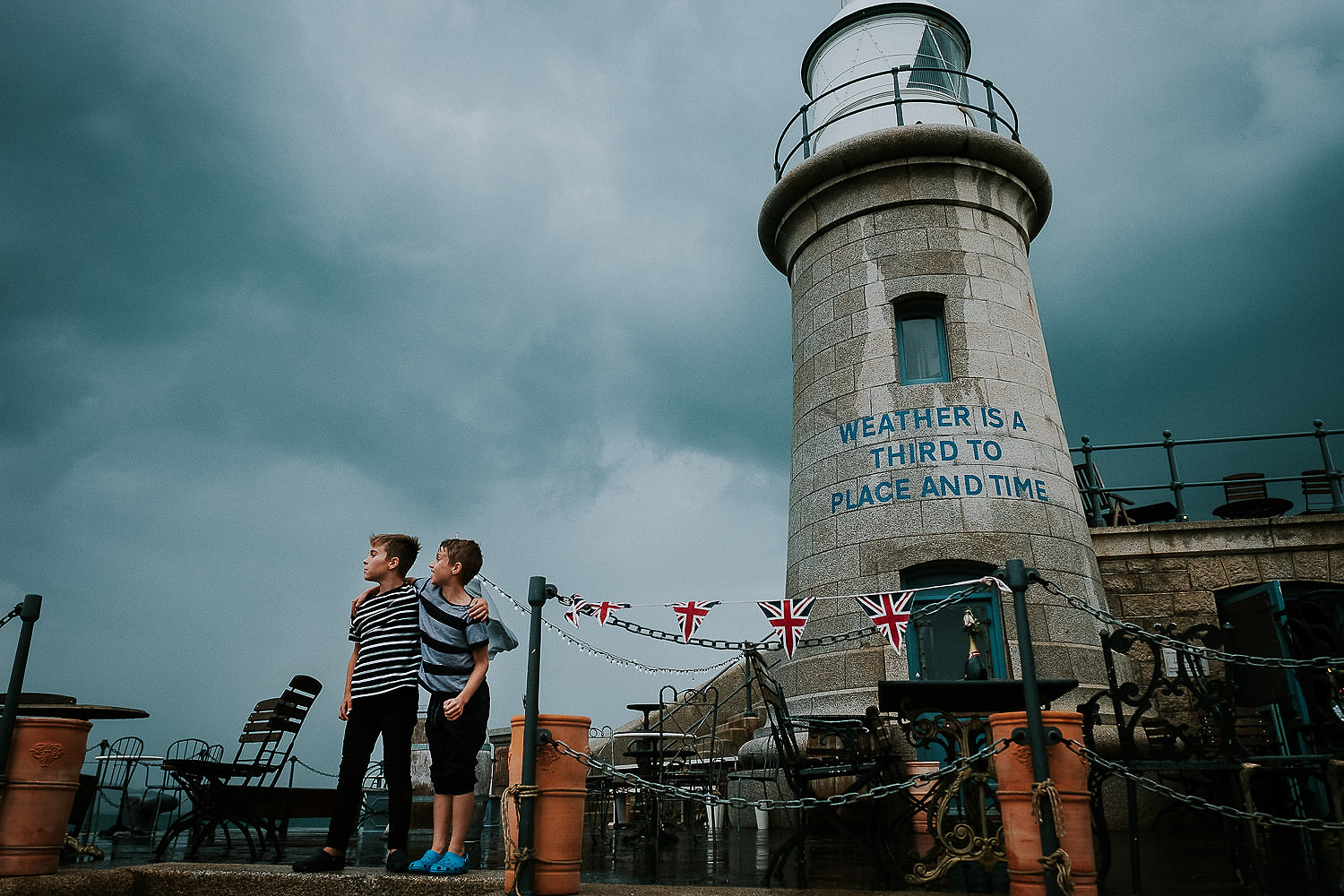 two boys at folkestone harbour arm on a stormy day vacation photo shoot uk
